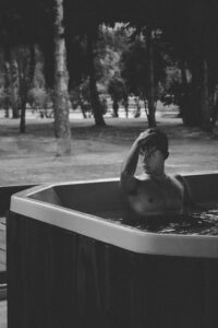 topless man bathing on outdoor bathtub